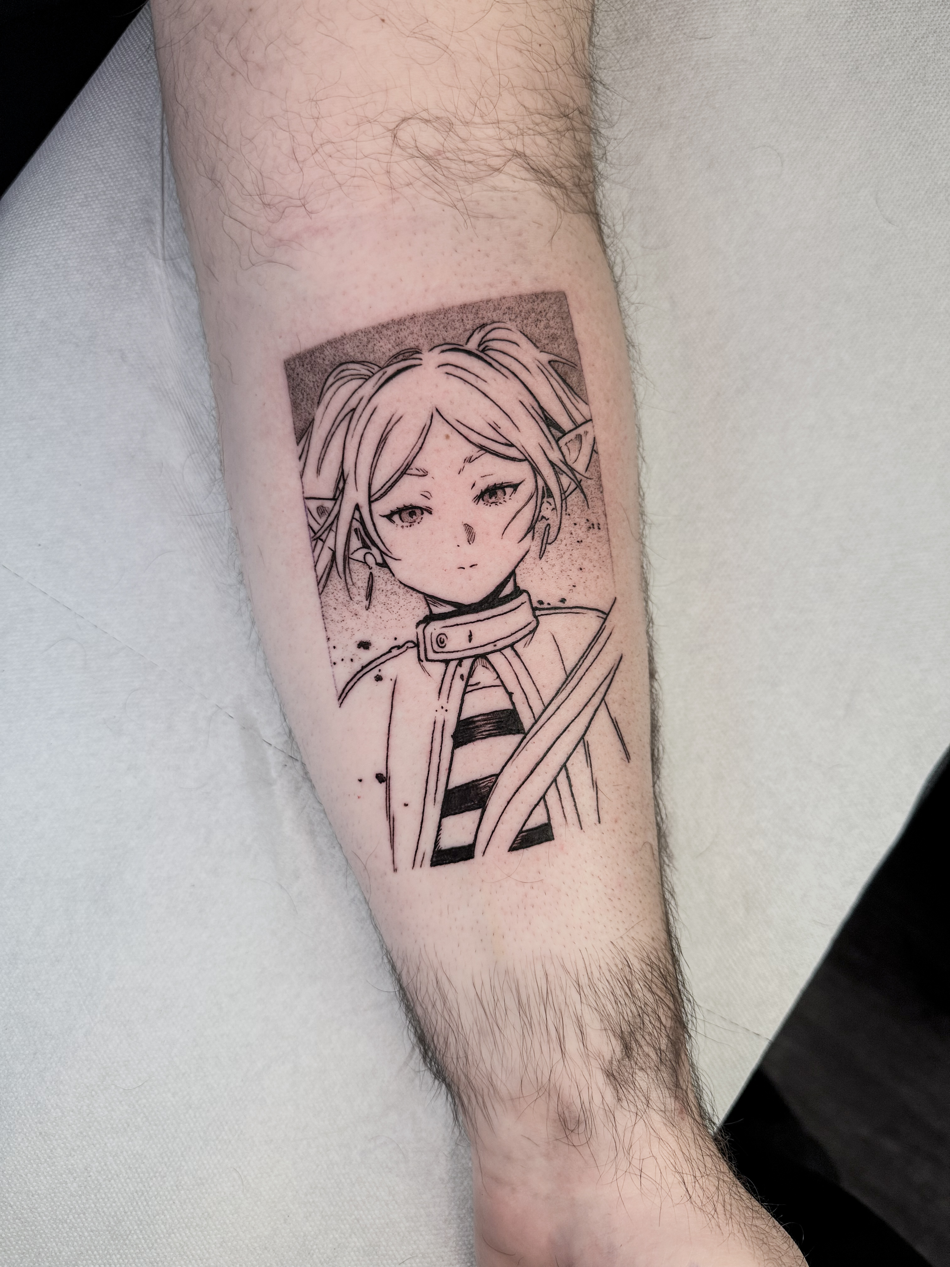 Tatouage blackwork fin de Frieren, inspiré d'une case du manga Frieren, réalisé à l'intérieur de l'avant-bras.
