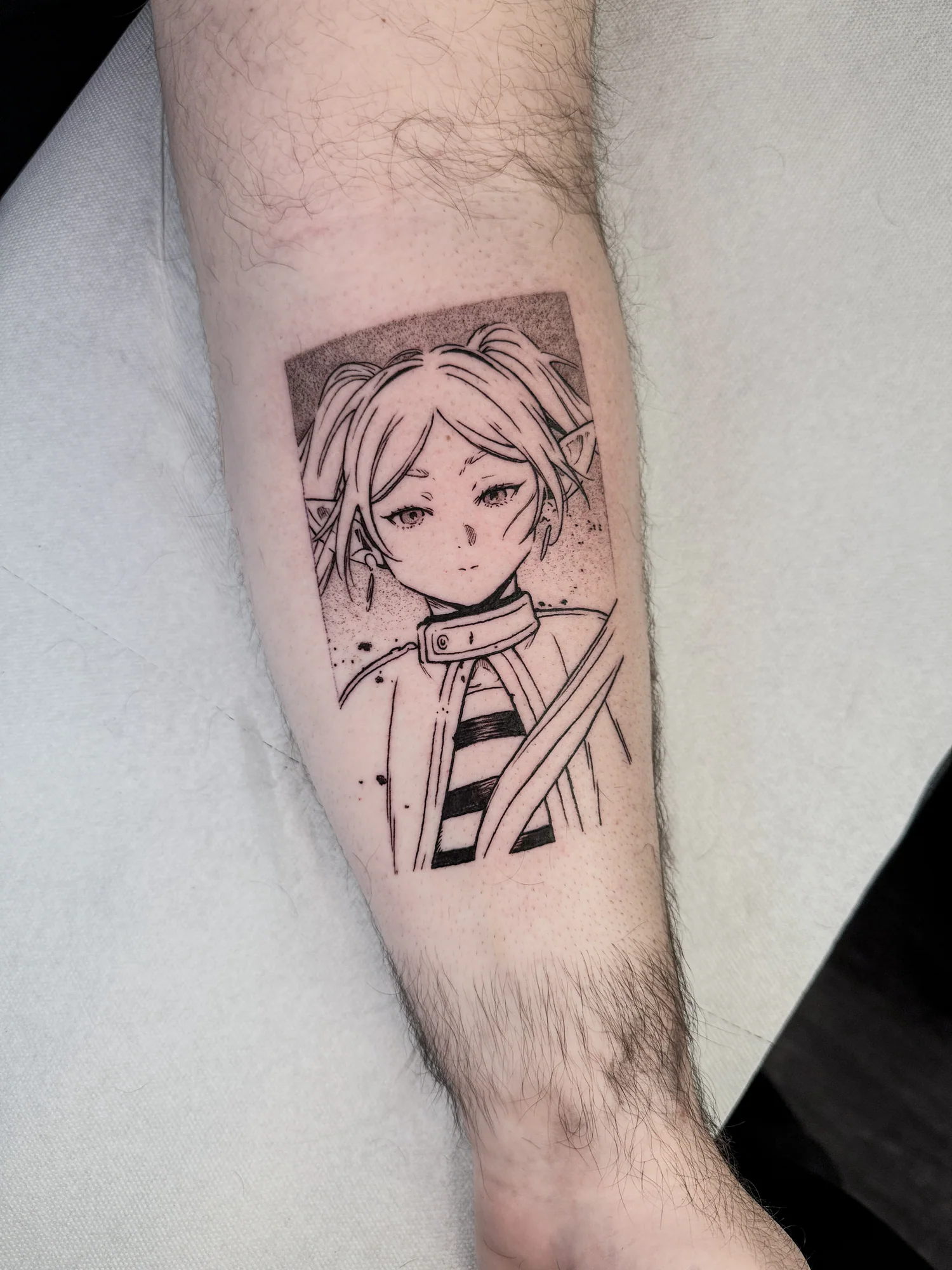 Tatouage blackwork fin de Frieren, inspiré d'une case du manga Frieren, réalisé à l'intérieur de l'avant-bras.