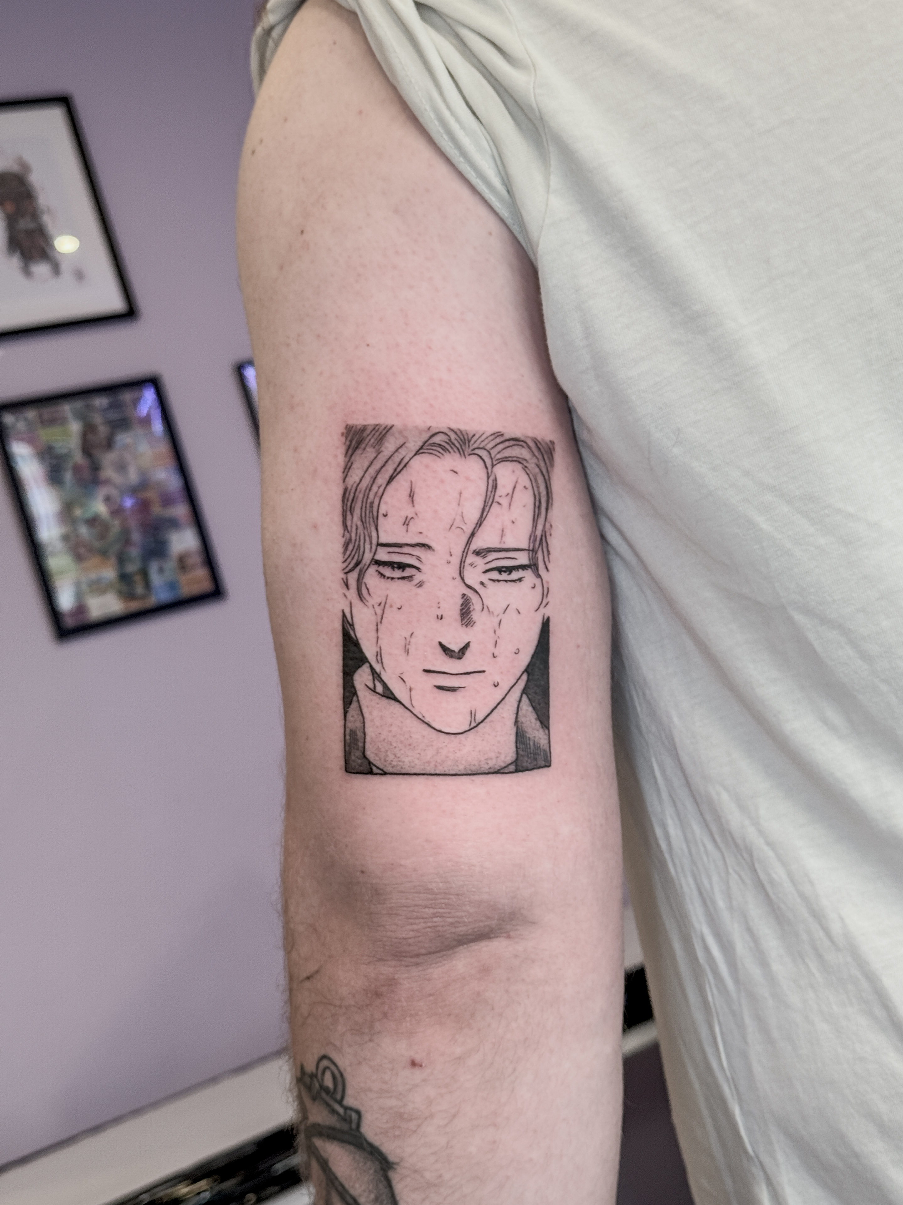 Tatouage blackwork fin de Johan, personnage du manga Monster, inspiré d'une case du manga et réalisé sur le haut du bras au-dessus du coude.