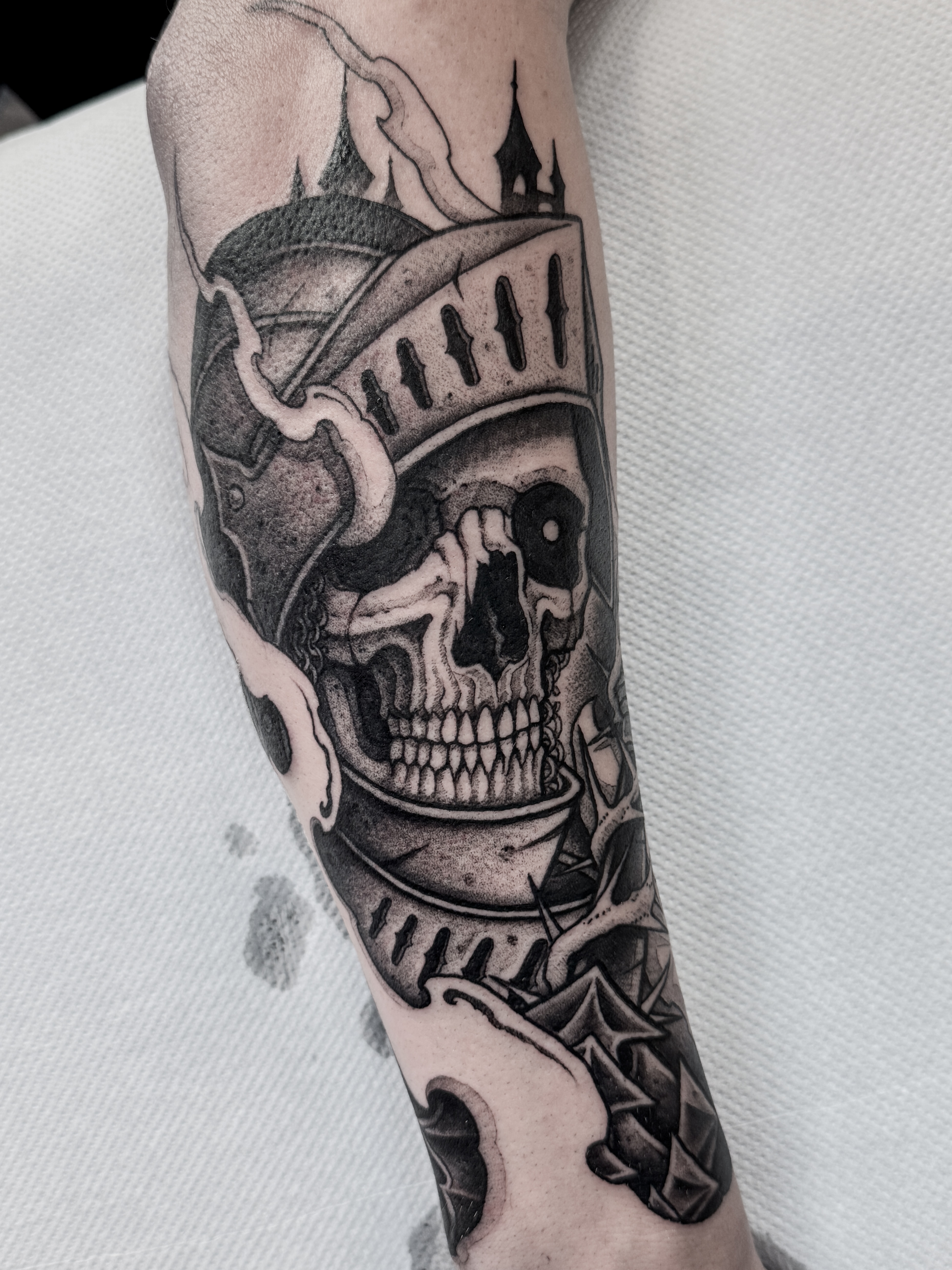 Tatouage blackwork d'un squelette en armure médiévale, réalisé sur l'extérieur de l'avant-bras dans un style sombre et détaillé.
